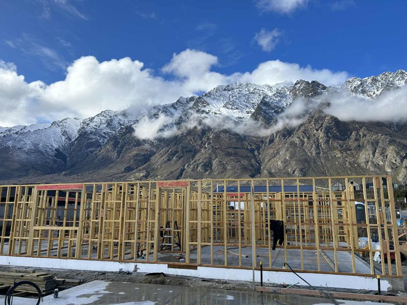Timber wall framing on a Project Built site with the snow-covered Remarkables behind
