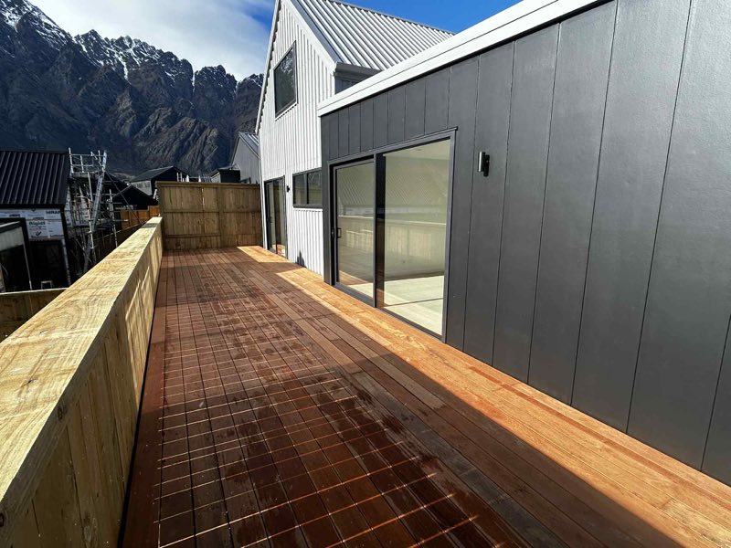 Hardwood deck running along dark vertical cladding with mountain views